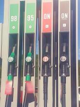 zdjęcie przedstawia dystrybutor paliwa jednej ze stacji paliw z pistoletami położonymi w stacji dokującej na paliwa benzynowe i diesla