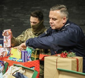 Pan Komendant Wojewódzki Policji pakujący prezenty dla potrzebującej rodziny