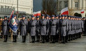 Zdjęcie kompani reprezentacyjnej na placu wraz ze sztandarem , a w tle flagi Polski