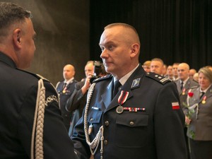 Komendant Wojewódzki Policji w Krakowie gratulujący policjantowi w stopniu młodszego inspektora