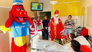 policjantka z świętym Mikołajem i aniołkami oraz maskotką polickiem stoją w pokoju z dziećmi leżącymi na łóżkach w szpitalu