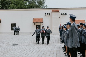 maszerujący poczet flagowy przezd policjantami