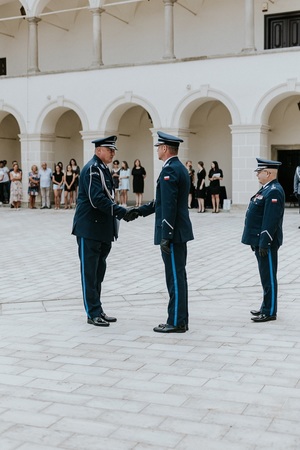 Naczelnik prewencji odbierający gratulacje od Komendanta Powiatowego Policji za którym stoi Zastepca komendanta wojewódzkiego