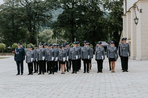 policjanci i policjantki stojący na dziedzińcu suskiego zamku przed uroczystością