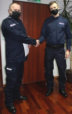 Komendant Powiatowy Policji trzymając Roberta za prawą rękę gratuluje awansu