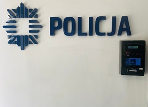 alkomat na ścianie i napis Policja