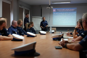 Policjanci siedzący przy stole na sali podczas szkolenia