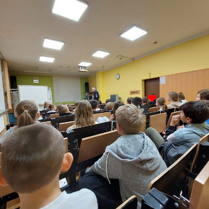 uczniowie podczas zajęć z policjantem siedzący w auli