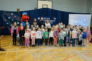 Dzieci z młodszych klas pozujący do zdjęcia na hali sportowej