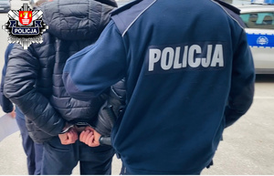 zatrzymany skuty kajdankami prowadzony przez policjanta