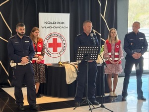 Trójka policjantów przemawiająca do seniorów