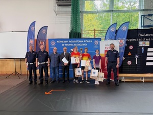 Finaliści w grupie starszej pozujący do zdjęcia z policjantami