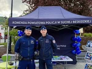 Dwóch policjantów stojących przed stoiskiem KPP w Suchej Beskidzkiej