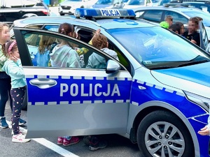 otwarty radiowóz i grupa dzieci próbująca wejść do środka