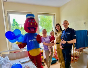 Mundurowi pozują do zdjęcia z dziewczynką i jej mamą