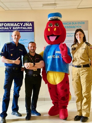 Mundurowi pozują do zdjęcia z polickiem i pracownikiem  szpitala