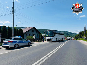 autokar stojący na drodze krajowej a przy nim radiowóz i policjanci
