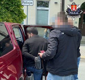Skuty kajdankami obywatel Gruzji wsiadający do samochodu w obecności policjantów