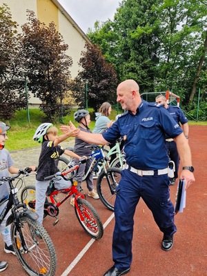 policjanci przybijający piątki uczestnikom egzaminu