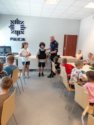 Chłopiec przebrany w hełm i kamizelkę policyjną