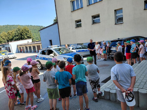 dzieci stojące wokół policyjnego radiowozu
