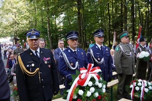 Stojący z wieńcem Zastępca Komendanta Powiatowego Policji w Suchej Beskidzkiej wraz z Komendantem Komisariatu Policji w Jordanowie oraz komendantem Powiatowym Państwowej Straży Pożarnej