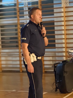 policjant ruchu drogowego z mikrofonem stojący przed rodzicami