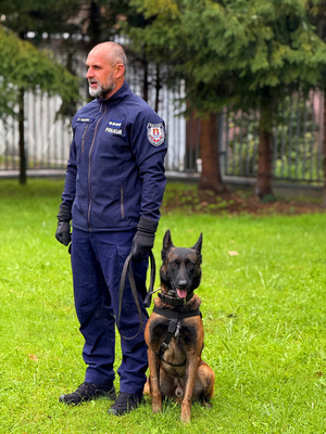 Policjant stojący z psem służbowym