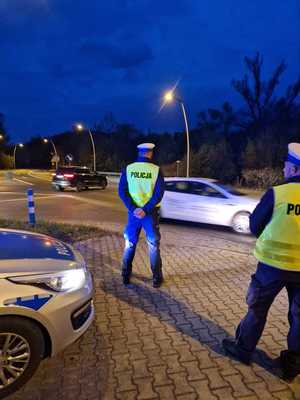 policjanci drogówki przyglądają się jadącym drogą kierowcom