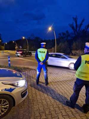 policjanci drogówki przyglądają się jadącym drogą kierowcom