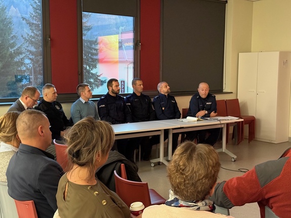 Siedzący policjanci i przedstawiciele Urzędu Miasta w Suchej Beskidzkiej