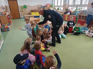 Policjant przybijający piątki z przedszkolakami