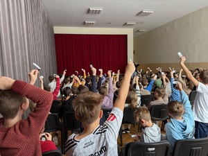 Dłonie dzieci uniesione w górę z wręczonymi odblaskami