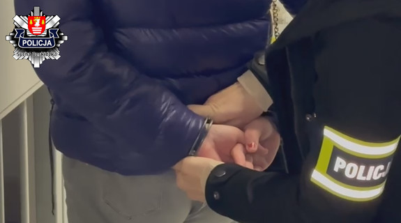 zdjęcie policjantki zakładającej kobiecie kajdanki