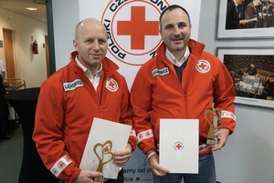 Pozujący do zdjęcia policjanci z dyplomami i statuetkami