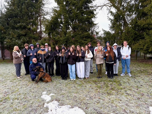 Pamiątkowe zdjęcie młodzieży z przewodnikiem i psem