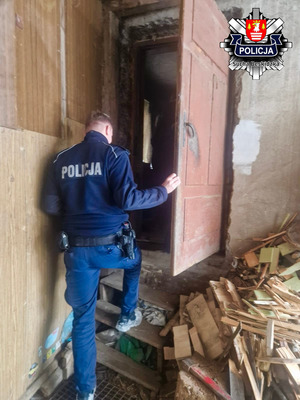 Dzielnicowy wchodzący do budynku