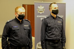 Sierżant Karol Kudzia i Dominik Czarny stojący przed odebraniem pochwały od Komendanta Powiatowego Policji