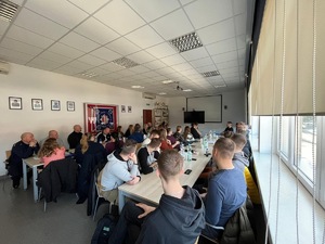 policjanci i pracownicy policji siedzący podczas szkolenia w sali audiowizualnej