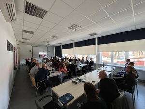 policjanci i pracownicy policji siedzący podczas szkolenia w sali audiowizualnej