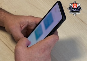 dłonie męzczyzny piszącego widomości na telefonie komórkowym