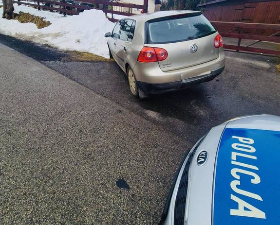 samochód marki volkswagen koloru złotego w rowie a za nim policyjny radiowóz