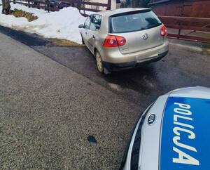 samochód marki volkswagen koloru złotego w rowie a za nim policyjny radiowóz