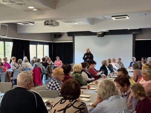 Seniorzy słuchający wystąpienia dzielnicowego