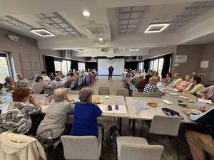 Dzielnicowy stojący pomiędzy grupą seniorów