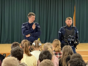 Przemawiający dzielnicowi do dzieci.