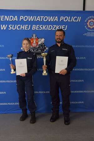 policjantka i policjant trzymający listy gratulacyjne