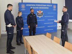 Komendant Powiatowy Policji w Suchej Beskidzkiej stoi przy reprezentantami jednostki przed wręczeniem listów gratulacyjnych