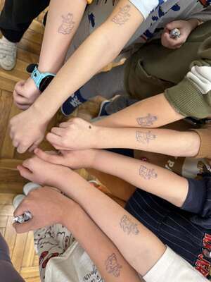 Ręce dzieci z pieczątkami z postacią smoka suskich policjantów