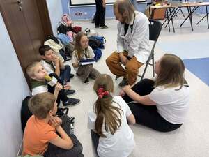 Lekarz siedzący przed grupa dzieci